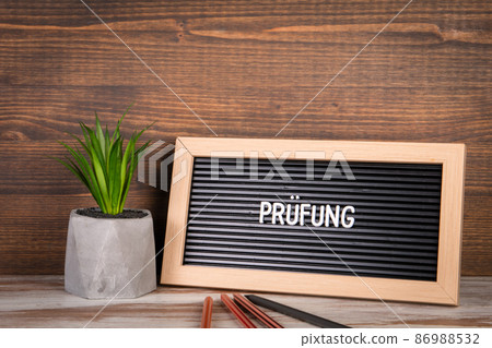 Audit text in german. Colored pencils and plant in a flower pot on the table 86988532