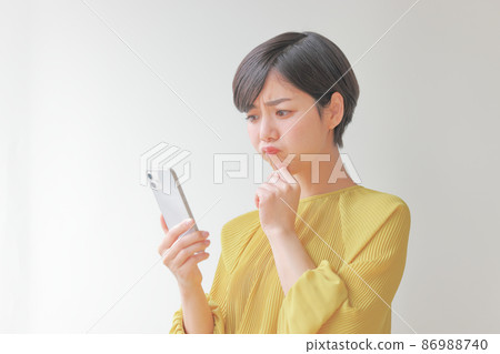 A pouty woman looking at her smartphone 1 A pouty woman looking at her smartphone 1 86988740