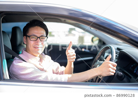A man looking at the camera giving a good sign with a smile from the car 86990128
