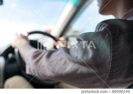 Back view of a man driving a car 86990149