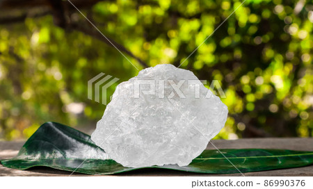 Crystal clear alum cubes or Potassium alum on wood plank. Chemical compound substance. Concept for beauty , spa and underarm treatment industrial.  86990376