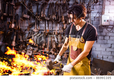 Authentic handsome indian man in leathern apron hammer industry small business 86991105