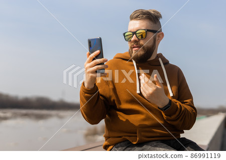Social media communication. Man video call using mobile smart phone spring outdoors 86991119