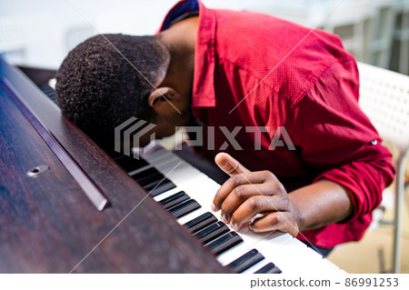 upset african american handsome musician man discontent singing, and teaching to play on piano upset african american handsome musician man discontent singing, and teaching to play on piano 86991253