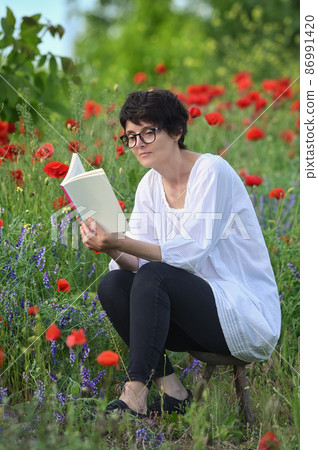 Woman In A Poppy Field Reading A Book 86991420