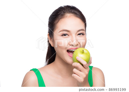 Attractive smiling young asian woman eating green apple isolated over white background. Attractive smiling young asian woman eating green apple isolated over white background. 86993199