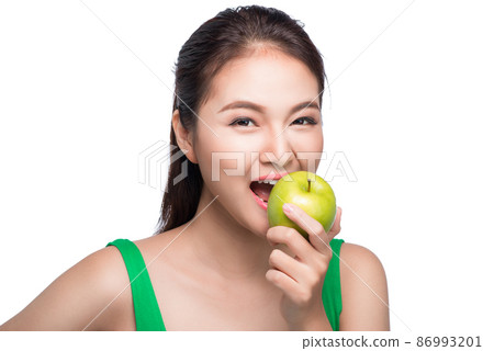 Young beautiful asian woman eating fresh green apple on white background 86993201