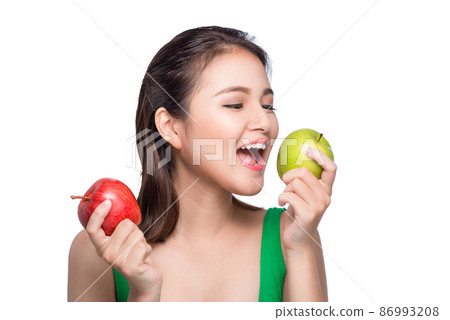 Young beautiful asian woman eating fresh green apple on white background 86993208