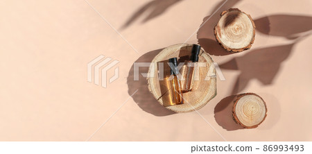 Banner of Perfume samples with yellow transparent liquid on woodcut on beige background with shadows above. Luxury and natural cosmetic presentation. Testers in sunlight. Shades and lights. Top view 86993493