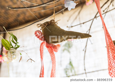Hanging ribbon and bird shape linen fabric and flower clear glass vase on background , artificial flowers hang in a wedding party or interior. Decoration indoors Hanging ribbon and bird shape linen fabric and flower clear glass vase on background , artificial flowers hang in a wedding party or interior. Decoration indoors 86996359