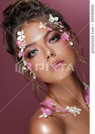 Beautiful caucasian woman with flowers on pink background. Beautiful caucasian woman with flowers on pink background. 86996666