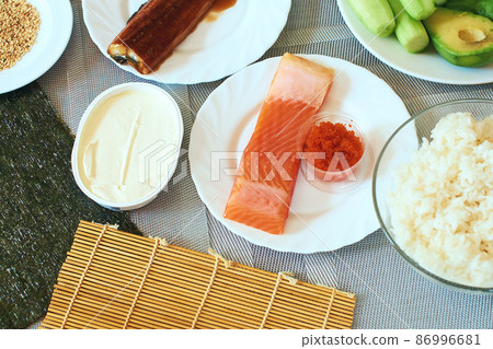 Homemade sushi rolls preparation. Traditional ingredients products foodstuff on the home kitchen table ready to be prepared. Asian food background. Top view. 86996681