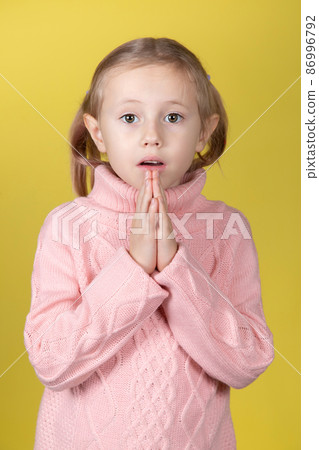 Begging little caucasian elementary age school girl looking at the camera Begging little caucasian elementary age school girl looking at the camera 86996792