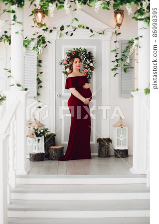 Charming pregnant woman in marsala dress posing on 86998395