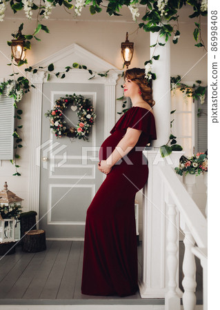 Charming pregnant woman in marsala dress posing on 86998408