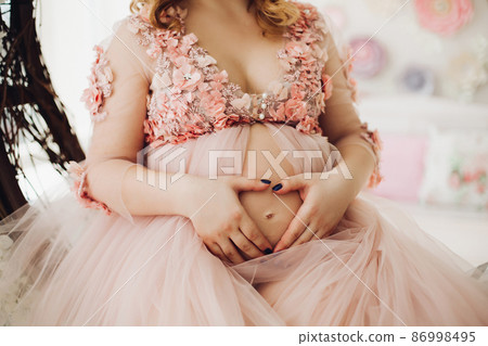 Close up of pregnant woman in powder long dress 86998495