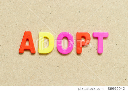 Color alphabet letter with word adopt on wood background 86999042
