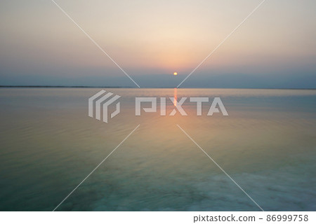 Beautiful sunrise at Dead Sea in Israel with rocks of salt at foreground 86999758
