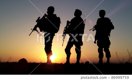Silhouette of soldiers with weapons at sunset 86999759