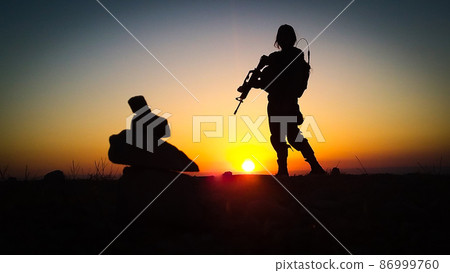 Silhouette of soldiers with weapons at sunset 86999760