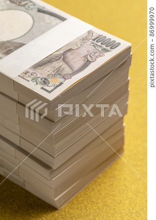 金色背景上的一疊百萬日元 86999970