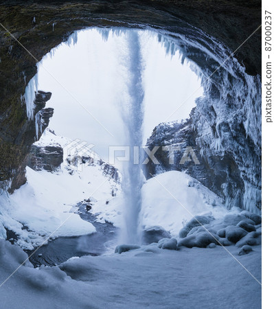 Kvernufoss waterfall, Iceland. View from inside the cave. Icelandic winter landscape. 87000237