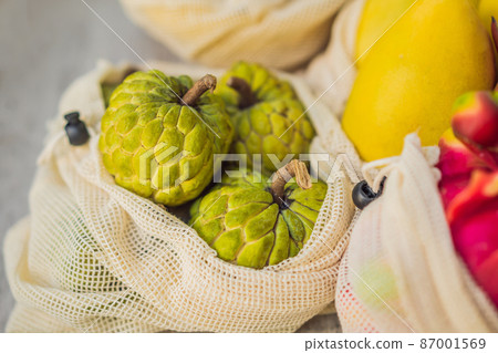 Fruit in a reusable bag on a stylish wooden kitchen surface. Zero waste concept, plastic free concept. Healthy clean eating diet and detox. Summer fruits Fruit in a reusable bag on a stylish wooden kitchen surface. Zero waste concept, plastic free concept. Healthy clean eating diet and detox. Summer fruits 87001569