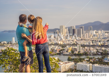 Happy family tourists on the background of Nha Trang city. Travel to Vietnam with kids Concept Happy family tourists on the background of Nha Trang city. Travel to Vietnam with kids Concept 87001849