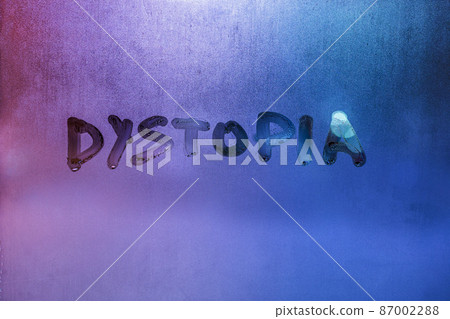 the word dystopia handwritten on wet window glass surface the word dystopia handwritten on wet window glass surface 87002288