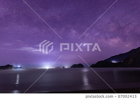 Venus illuminates the sea with the Milky Way and the lighthouse flowing sideways in the starry sky that spreads over Eboshi Island alongside Eboshi Island from Nienami Beach, Nichinan City, Miyazaki Prefecture. Venus illuminates the sea with the Milky Way and the lighthouse flowing sideways in the starry sky that spreads over Eboshi Island alongside Eboshi Island from Nienami Beach, Nichinan City, Miyazaki Prefecture. 87002413