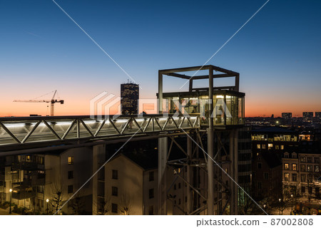 Brussels, Belgium - Tourist on the Poelaert pedestrian bridge, overlooking a colorful cityscape 87002808