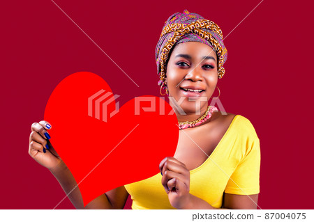 attractive lovely south woman with turban holding in hands heart isolated over red background valentine's day february 14 87004075