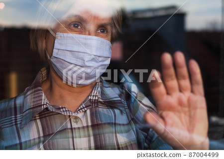 Elderly caucasian woman wearing hand made protective face mask Elderly caucasian woman wearing hand made protective face mask 87004499