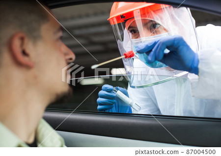 Medical UK NHS worker performing drive-thru COVID-19 test Medical UK NHS worker performing drive-thru COVID-19 test 87004500