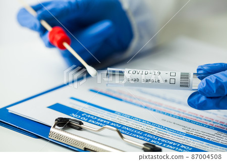 Medical worker holding Coronavirus COVID-19 NP OP swab sample test kit 87004508