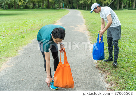 Young people cleaning the park 87005508