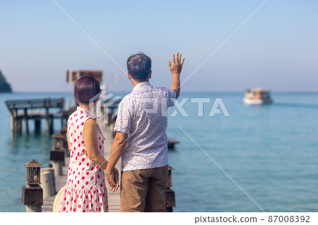 Middle aged couple relaxing on wooden pier in holiday at koh kood ,Thailand. Middle aged couple relaxing on wooden pier in holiday at koh kood ,Thailand. 87008392
