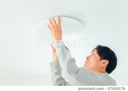 穿著工作服的男士檢查照明設備(檢查) 穿著工作服的男士檢查照明設備(檢查) 87009279
