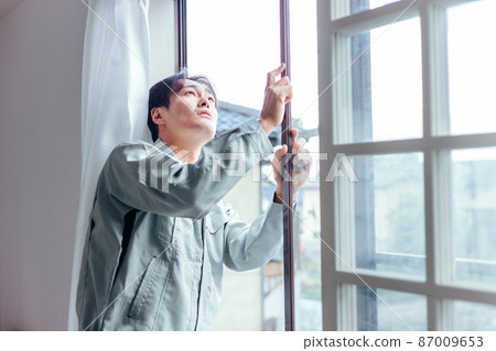 A man in work clothes checking the window booklet A man in work clothes checking the window booklet 87009653