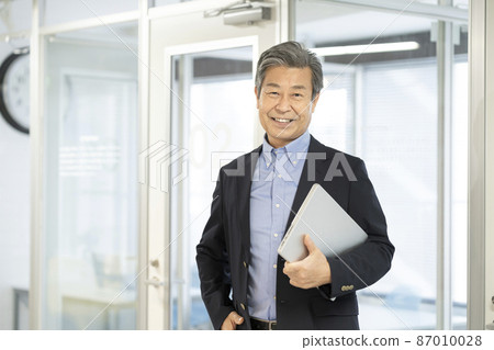 一位 60 多歲的高級商人，帶著筆記本電腦 87010028