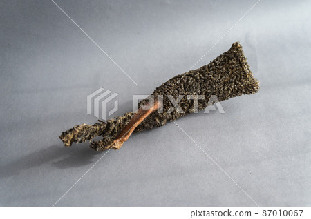 Pet treats against a gray background. Dried beef tripe. Pieces of natural, wholesome chewable dog treats. 87010067