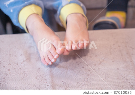 A close-up of my grandson's bare feet. Two feet with unevenly trimmed fingernails. A child in pajamas. A close-up of my grandson's bare feet. Two feet with unevenly trimmed fingernails. A child in pajamas. 87010085