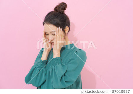 拿著她的頭的女性顏色背景 拿著她的頭的女性顏色背景 87010957