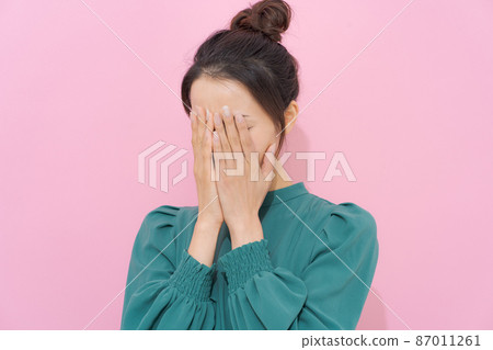 覆蓋面部的女性顏色背景 覆蓋面部的女性顏色背景 87011261