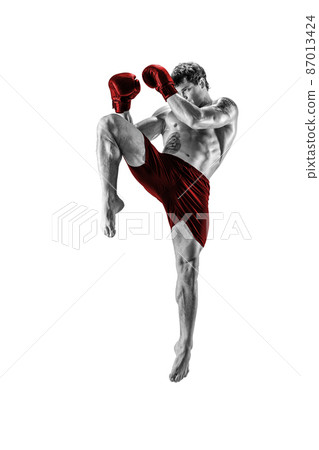 Full length of kickboxer in red sportswear who fighting on white background. Black and white Full length of kickboxer in red sportswear who fighting on white background. Black and white 87013424