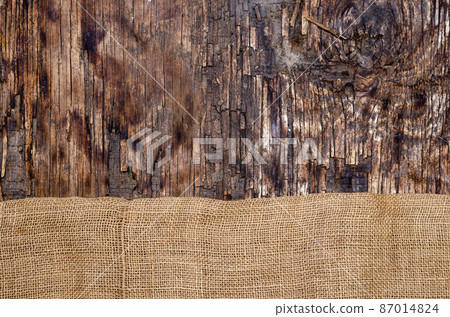 Fabric sackcloth on dark wooden background. 87014824