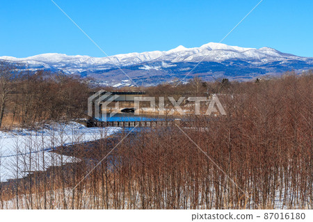 Mount Horohoro and Mt. Tokushunbetsu as seen from the bridge over the Shikiu River in Shiraoi Town, Hokkaido [January] 87016180