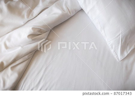 White bedding sheets and pillow in bedroom. Morning lifestyle concept. 87017343