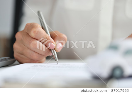 Hands of client signing car rental form closeup Hands of client signing car rental form closeup 87017963