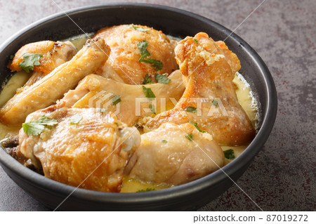 Shkmeruli is a traditional Caucasian Georgian dish of chicken in garlic sauce closeup in the pot. Horizontal Shkmeruli is a traditional Caucasian Georgian dish of chicken in garlic sauce closeup in the pot. Horizontal 87019272
